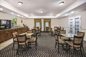 斯蒂芬维尔斯蒂芬维尔拉金塔旅馆及套房酒店的一间带桌椅的餐厅和一间酒吧