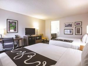 亚特兰大亚特兰大市中心 - 巴克黑德拉金塔旅馆及套房的酒店客房设有两张床、一张桌子和一台电视。