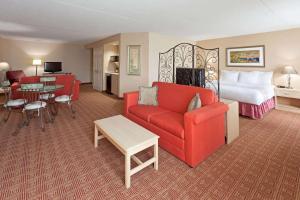 加登城拉魁塔花园城市酒店的酒店客房,配有一张床和一张红色的沙发