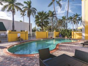 朱庇特朱庇特拉昆塔酒店的一个带椅子的游泳池,棕榈树