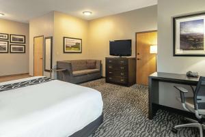 利弗莫尔利弗莫尔拉昆塔旅馆的酒店客房配有一张床、一张书桌和一台电视。