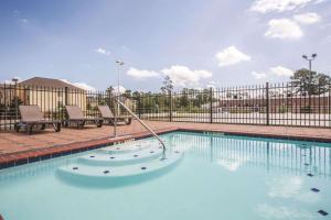 哈蒂斯堡哈蒂斯堡59号州际公路拉金塔旅馆及套房的一座带金属围栏的大型游泳池