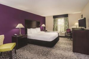 路易斯威尔La Quinta Inn & Suites by Wyndham Louisville East的酒店客房,配有床和电视