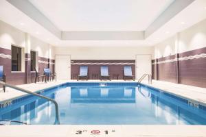 威奇托La Quinta by Wyndham Wichita Northeast的一座配有桌椅的酒店游泳池