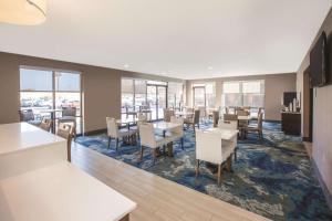 埃辛顿费城机场拉金塔旅馆及套房的用餐室设有桌椅和窗户。