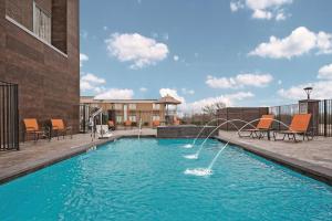 大草原城达拉斯大草原北拉昆塔酒店的一座建筑中间的游泳池,有一个喷泉