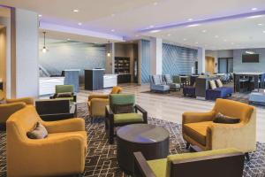 麦克多诺La Quinta Inn & Suites by Wyndham Atlanta South - McDonough的酒店大堂设有长沙发和椅子。