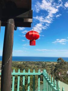 莱克斯恩特伦斯山羊与鹅住宿加早餐旅馆的悬挂在俯瞰大海的阳台上的红色吊灯