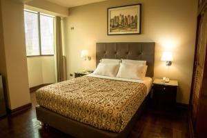 利马雷克萨斯酒店的一间卧室配有一张床、两盏灯和一个窗户。
