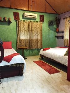 曼谷香提旅馆的一间卧室设有两张床,拥有绿色的墙壁
