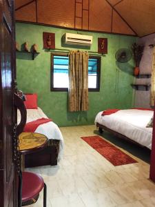 曼谷香提旅馆的一间卧室配有两张床、一张桌子和一把椅子