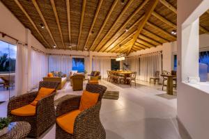 卡诺阿斯德蓬萨尔Qalma Punta Sal的开放式客厅配有椅子和桌子