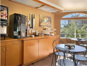 洛杉矶洛杉矶市区速8酒店的厨房配有桌椅和微波炉。