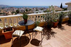 托雷德尔马尔Villa Borja的阳台配有桌椅和植物