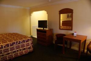 博伟公园考罗琳旅馆的一间酒店客房,配有一张床、一台电视和一张桌子