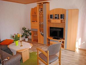 克洛斯特Ferienwohnungen Insel Hiddensee RU的客厅配有桌子和电视。