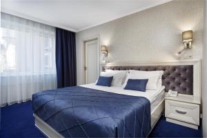利沃夫欧洲酒店的酒店客房,配有一张带蓝色床单的大床