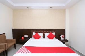 哈里瓦Hotel Le central的一间卧室配有一张带红色枕头的大床