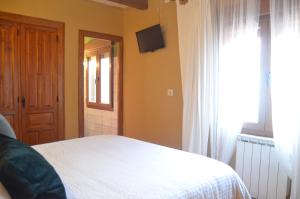 纳瓦雷东达德格雷多斯Hostal Refugio De Gredos的卧室配有白色的床和窗户。