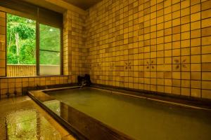 箱根桐谷箱根庄酒店的带浴缸的瓷砖浴室设有窗户