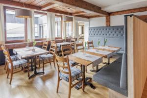 努齐德斯德纽酒店的餐厅设有木桌、椅子和窗户。