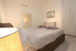 热那亚Lovely Apt Old Town with FREE PRIVATE PARKING included!的一间卧室配有一张大床和毛巾