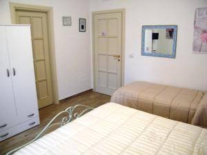 丰迪B&B Il Cantuccio的一间卧室配有两张床、一个梳妆台和镜子
