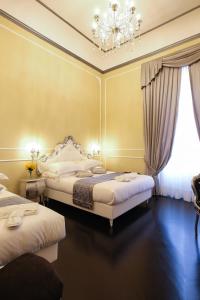 佛罗伦萨B&b Kingsman的一间卧室配有两张床和吊灯。