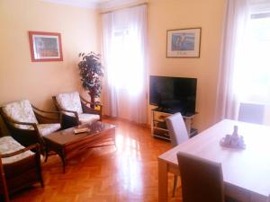 马德里Apartamento en Retiro的客厅配有桌椅和电视。