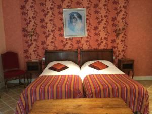 Chénas莱斯德桑纳豪华旅馆的卧室配有两张床,墙上挂着一幅画