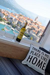 科尔丘拉Apartment Marina的一瓶葡萄酒坐在带枕头的窗台上