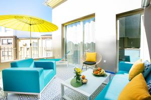 马拉加Graffiti Suites Málaga的客厅配有蓝色的家具和黄色的雨伞