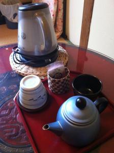 京都洛顶旅馆的茶壶和茶盘,桌子上,有咖啡壶