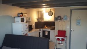 莱萨布勒-多洛讷L'Océane ( Résidence La Joséphine )的一间小厨房,配有白色家电和红色椅子