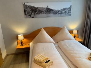 科赫姆Stumbergers Hotel的一间卧室配有一张带白色床单和两盏灯的床。