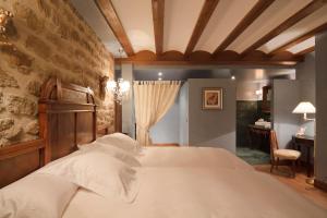 拉瓜迪亚洛斯帕拉赫斯酒店的一间卧室设有一张床和石墙