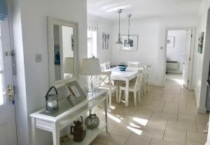班特里Sea Lodge Holiday Home的白色的用餐室配有白色的桌椅