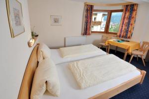 费斯Apart Hotel Garni Kofler的酒店客房设有两张床和一张桌子。
