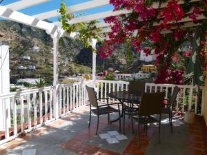 巴列埃尔莫索Casa Rural Lili的鲜花阳台的桌椅