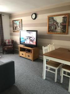 伦敦Lovely One Bedroom Apartment in Stratford的客厅配有平面电视和桌子。