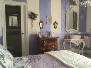 代森扎诺-德尔加达La maison delle favole的卧室设有紫色墙壁、水槽和床。