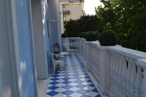 代森扎诺-德尔加达La maison delle favole的阳台设有白色的栅栏和蓝色及白色的瓷砖。
