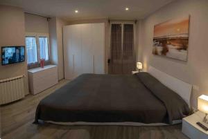卡莫利Portofino House的一间卧室配有一张大床和电视