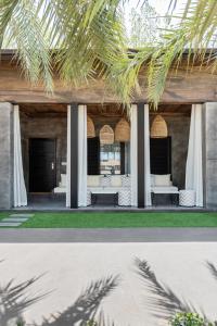 阿布扎比阿联酋公园度假酒店的两幅房子的照片,两把椅子和一个门廊