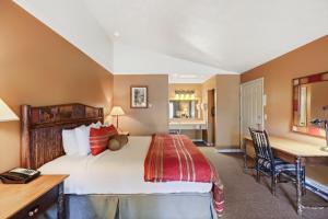 莫兰弗拉格牧场河源小木屋旅馆 的酒店客房配有一张床、一张书桌和一张书桌。