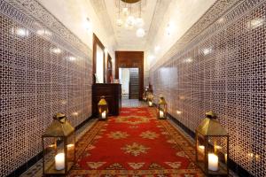 马拉喀什Riad Daria Suites & Spa的走廊上设有灯和红地毯,还有一间房间