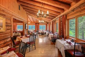 河狸溪珍妮湖小屋酒店的用餐室设有桌椅和窗户。