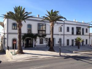 塔里法达尔司亚宾馆的一座白色的建筑,前面有棕榈树