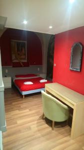 安锡萨沃酒店的卧室设有红色墙壁、一张床和一张书桌