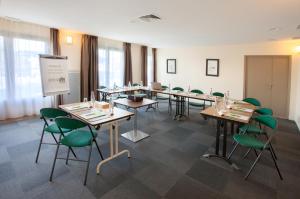 普瓦捷普瓦捷钟楼酒店的一间会议室,配有桌子和绿色椅子